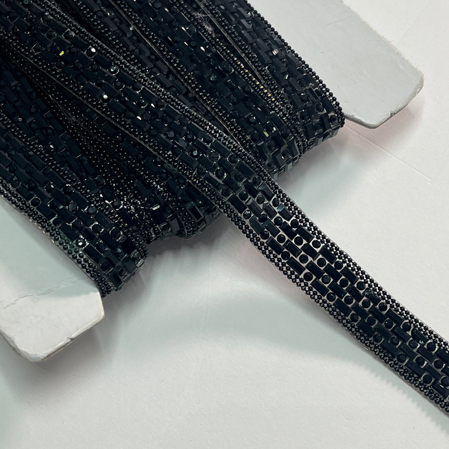 A stunning Art Deco inspired trim created with crystals and baguette shaped polished stones for sparkle, with a tiny twin bead edging. This is an iron-on embellishment with a transparent gel backing film and is very easy to cut to length.