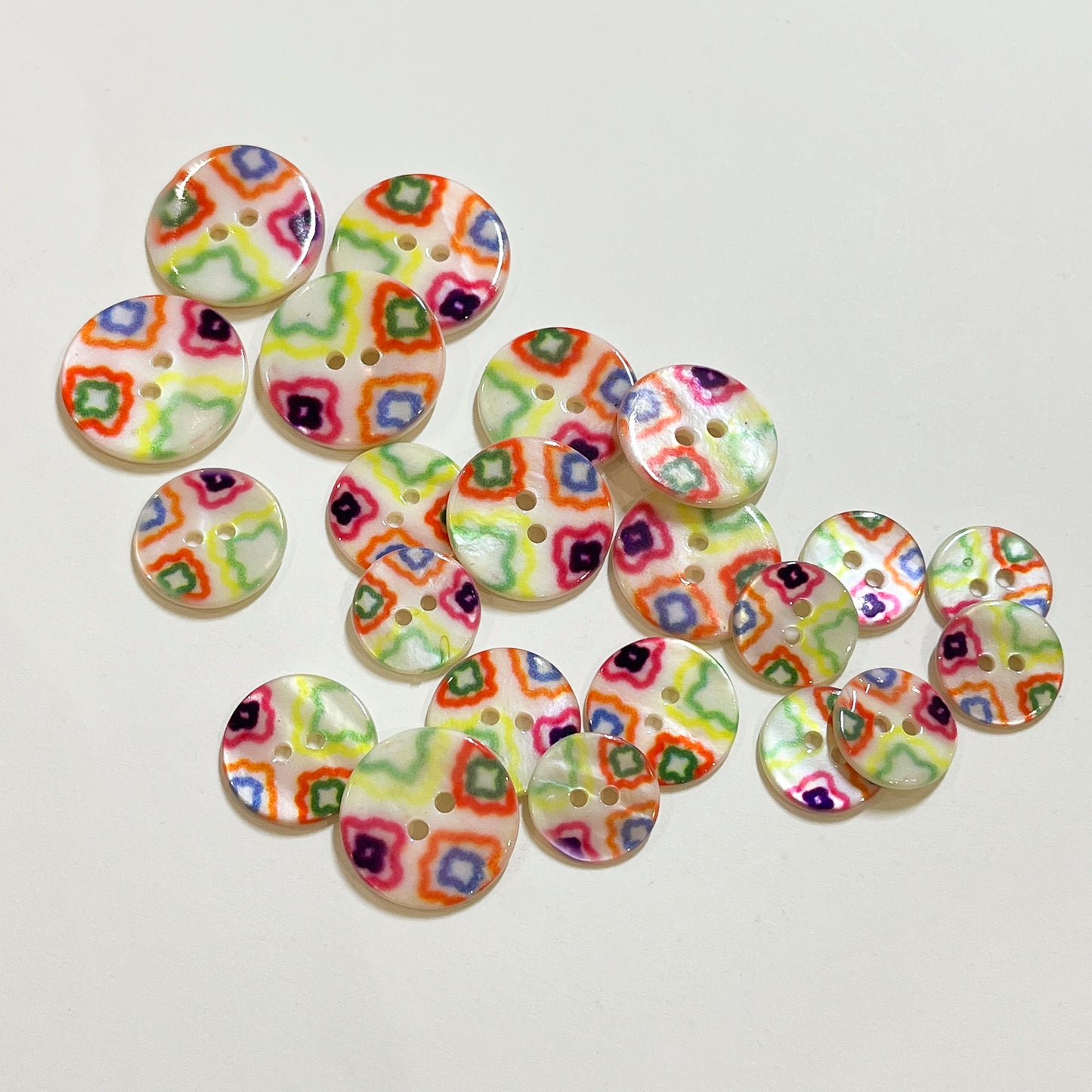 Very pretty, 2 hole river shell buttons with a bright geometric design.
