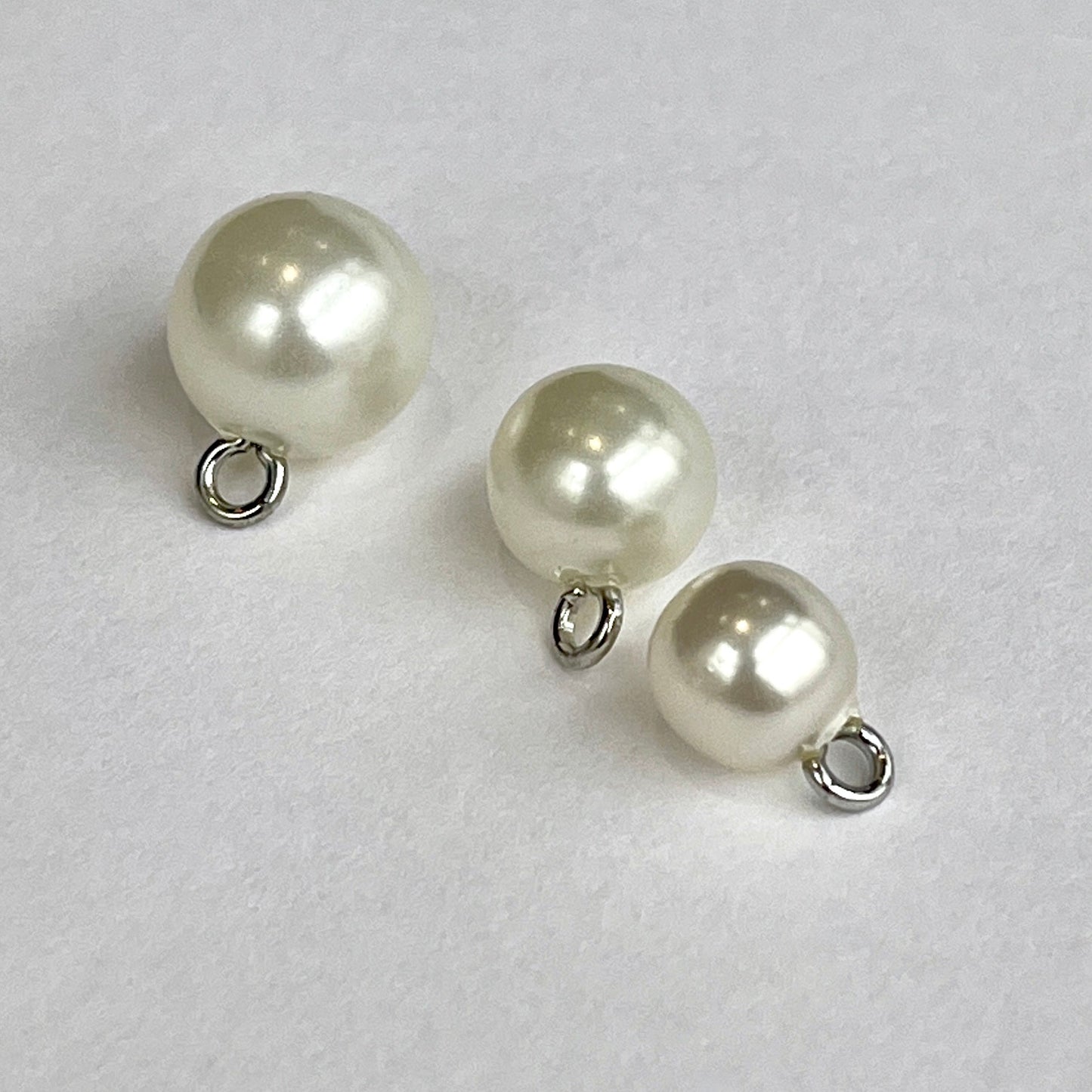 Pearl bridal ball buttons with metal shank perfect for bridal wear, baptism and Christening gowns or even a fancy cardi! Available in either white or ivory and 3 sizes. Close up image of 3 sizes of faux pearl buttons.