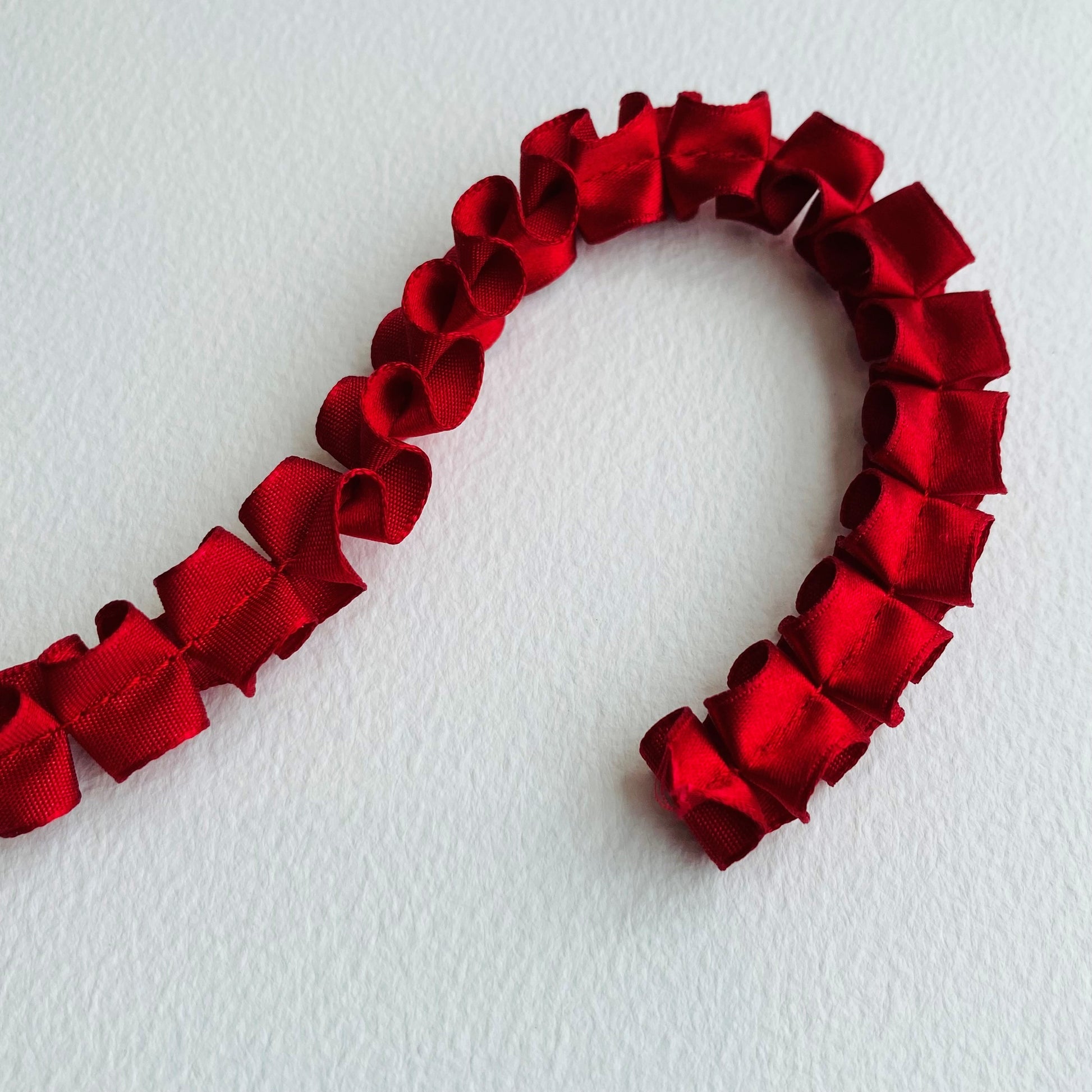 15mm Pleated Satin ribbon by MOKUBAA beautifully soft pleated satin ribbon trim by Mokuba, carefully gathered, held together by a single stitch running through the middle, which comes in two beautiful colours. red, scarlet, ruby ribbon