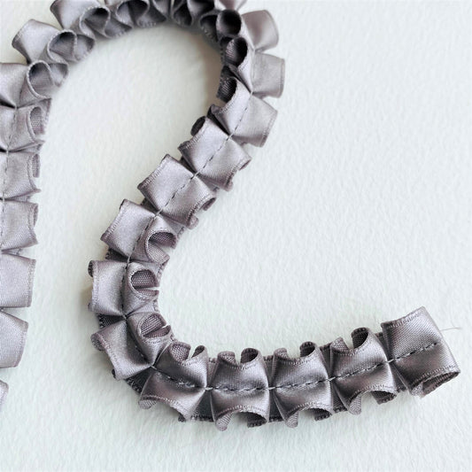 15mm Pleated Satin ribbon by MOKUBAA beautifully soft pleated satin ribbon trim by Mokuba, carefully gathered, held together by a single stitch running through the middle, which comes in two beautiful colours. silver, grey, gunmetal ribbon