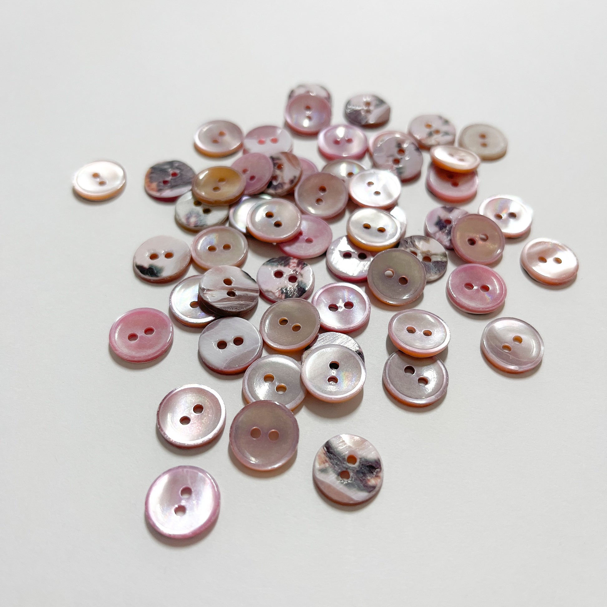 Set of 10 shirt buttons. Beautiful 2 hole Trocas shell shirt buttons in varying shades of pink.Deadstock shell buttons.