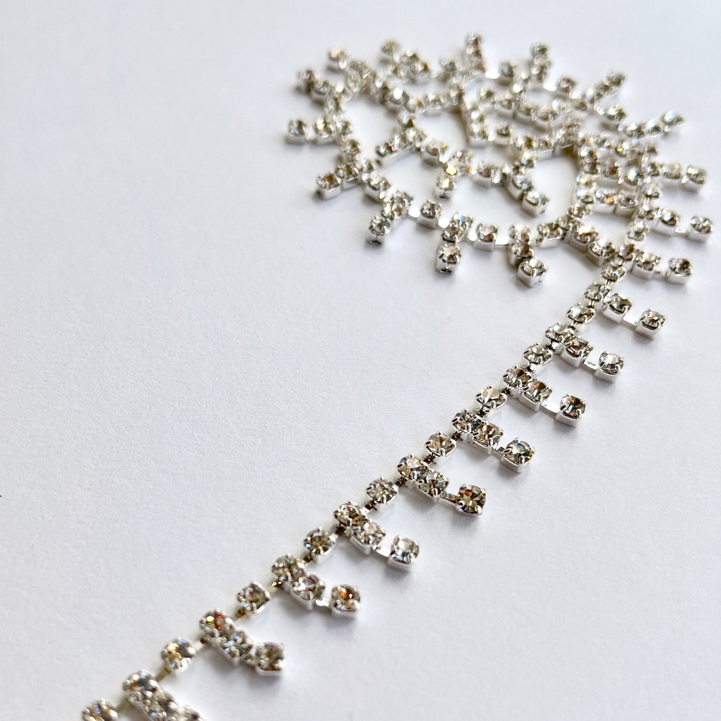 Delicate sparkly rhinestone fringe trim made premium high grade diamanté crystals set in a flexible metal chain casing. Popular for bridal wear, evening wear, crafts, jewellery and headband making.