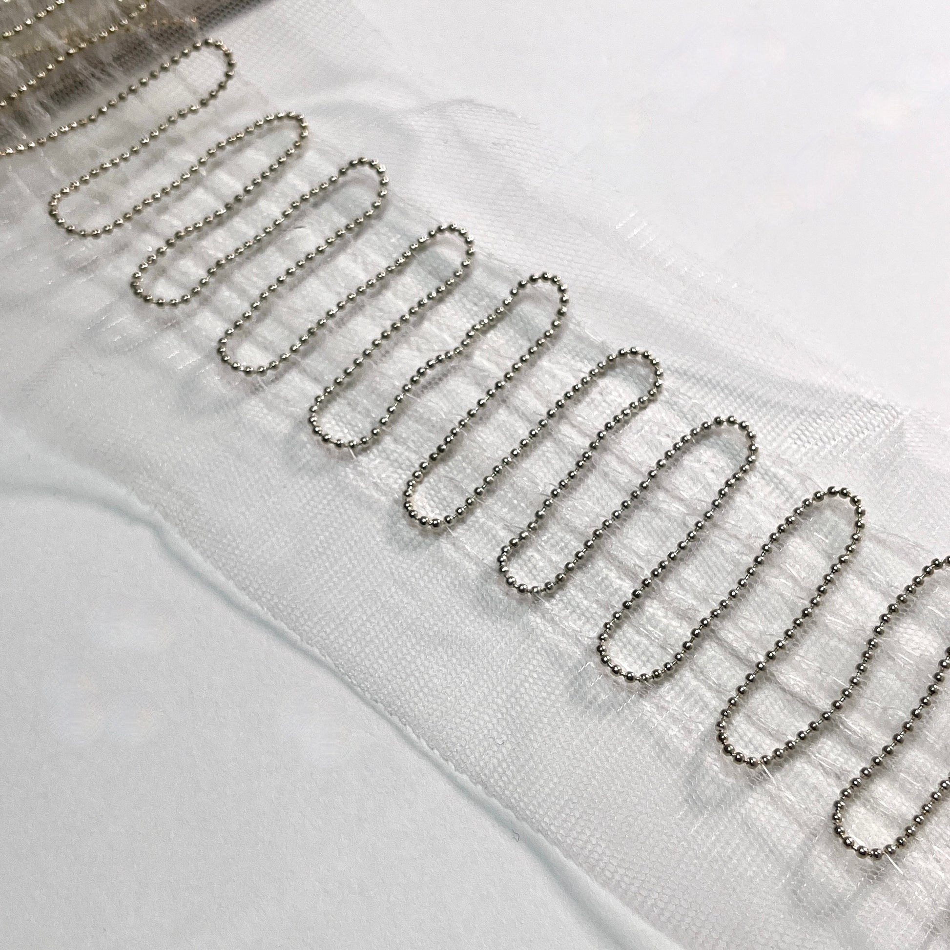 This is a super fine and unusual beaded trim, with a 1.5mm ball chain expertly stitched in a Serpentine pattern to a tulle base which would be a great base for extra beading work, should it be required. Perfect to embellish borders, waists, for bridal wear, evening wear, crafts, jewellery and headband making.