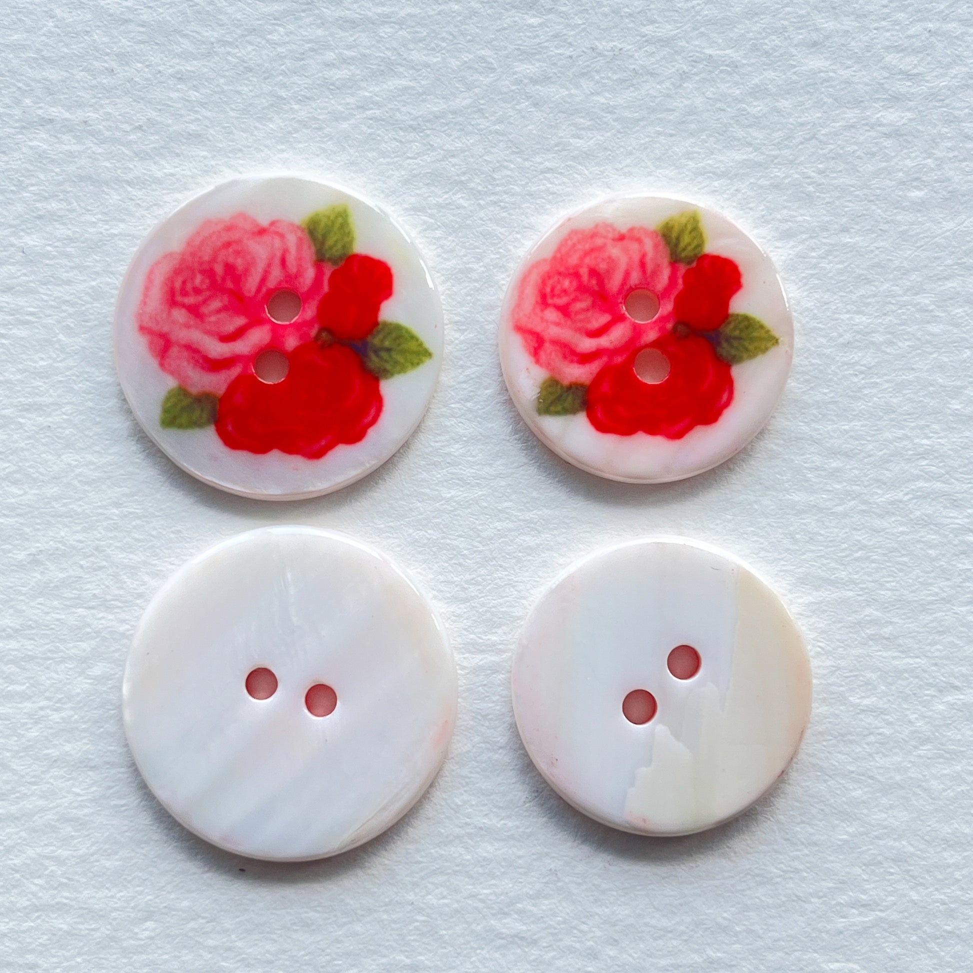 pretty lacquered Agoya shell buttons with flower design in red and pink. Deadstock haberdashery. Choose our range of vintage buttons, trims & sewing accoutrement rescued from a London haberdasher. Sew sustainably.