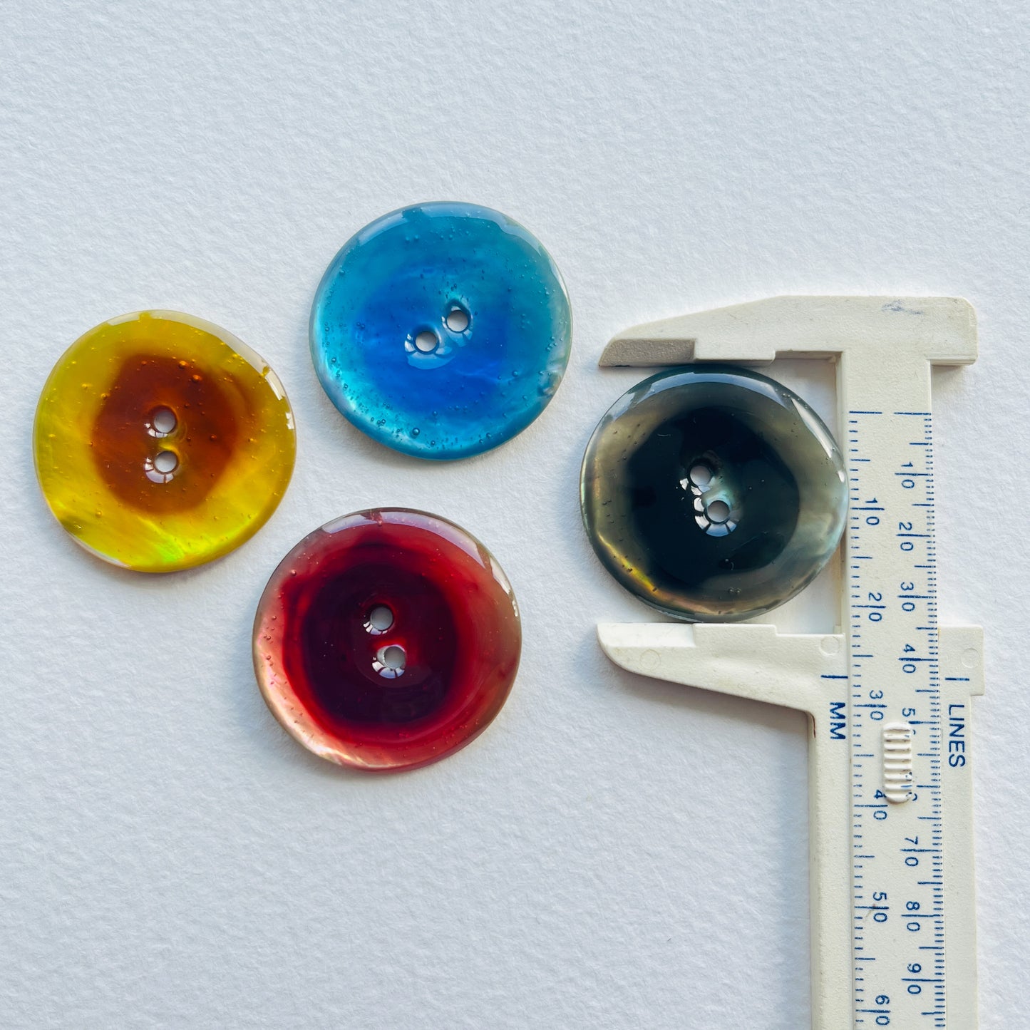 Colourful lacquered Agoya shell buttons - 28mm/44 ligne .Deadstock haberdashery. Choose our range of vintage buttons, trims & sewing accoutrement rescued from a London haberdasher. Sew sustainably.